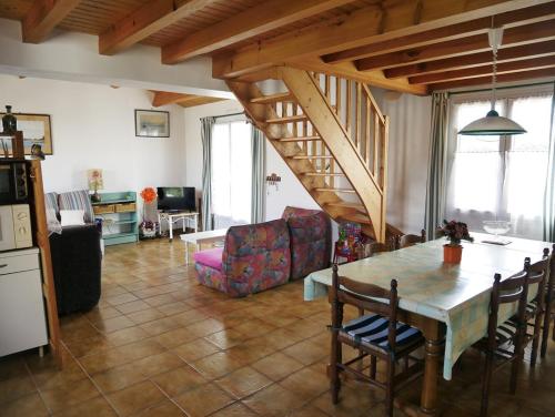 une cuisine et un salon avec une table et des chaises dans l'établissement Le jardin de la mer, à Saint-Hilaire-de-Riez