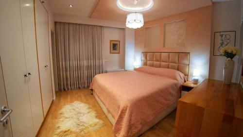 a bedroom with a bed and a table and a door at Central Luxe Apartment in Tirana
