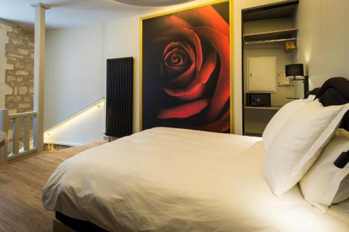 une chambre avec un lit avec un tableau représentant une rose dans l'établissement Love Room centre ville de Cognac, à Cognac