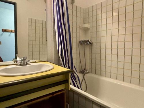 une salle de bain avec un lavabo et un rideau de douche dans l'établissement Appartement 2 pièces avec terrasse et parking à 150m de la mer - FR-1-225-451, à Argelès-sur-Mer