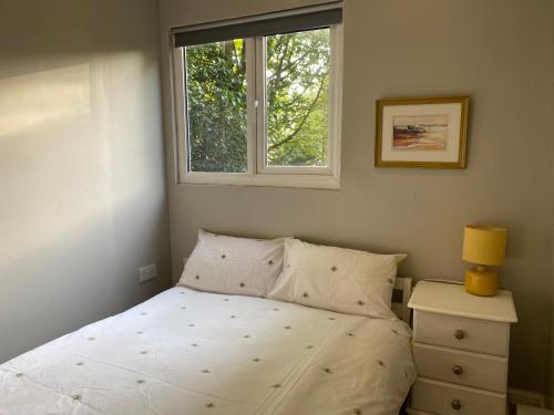 - une chambre avec un lit blanc et une fenêtre dans l'établissement The Potting Shed, à Invergowrie