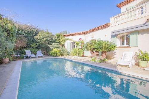 une piscine devant une maison dans l'établissement Villa Flora, à Carqueiranne