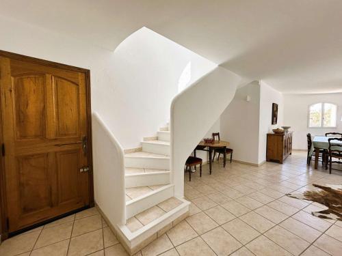 un escalier blanc dans un salon avec une porte dans l'établissement Villa Flora, à Carqueiranne