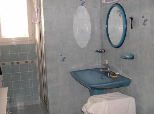 une salle de bain avec un lavabo bleu et un miroir dans l'établissement L'Oberlin de la ville, à Saint-Hilaire-de-Riez