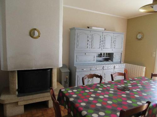 une salle à manger avec une table et une cuisine dans l'établissement L'Oberlin de la ville, à Saint-Hilaire-de-Riez