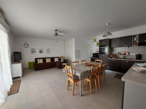 une cuisine et un salon avec une table et des chaises dans l'établissement La Deliciosa de Sion, à Saint-Hilaire-de-Riez