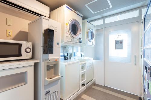 a kitchen with white appliances and a microwave at Sun Days Kagoshima in Kagoshima