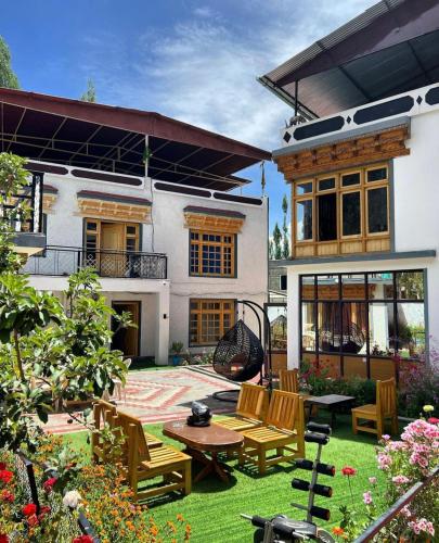 a patio with chairs and a table in front of a house at Sky land guest house in Leh