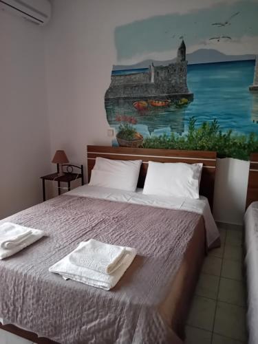 una camera da letto con un letto e un dipinto sul muro di LITTLE LEPANTO ad Áfitos