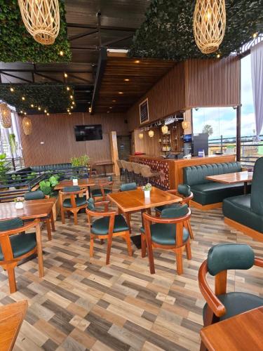 a restaurant with tables and chairs and a bar at LA BEILA HOTEL MERU in Meru