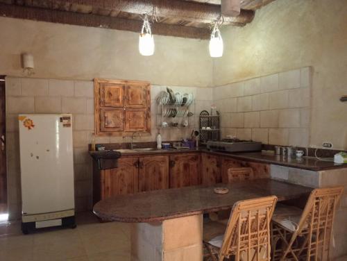 una cucina con armadi in legno e frigorifero bianco di Paradise Hosting Group Siwa a Siwa