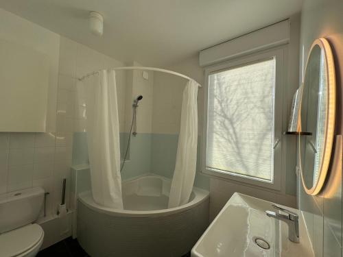 ein Badezimmer mit einer Badewanne, einem WC und einem Waschbecken in der Unterkunft Villa Denise Grand Gîte in Barneville-Carteret