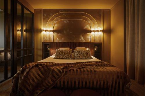 ニースにあるHotel Gounod Fully Renovatedのベッドルーム1室(ヘッドボードと照明付きのベッド1台付)