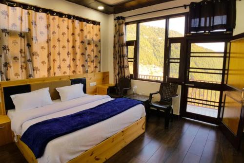a bedroom with a large bed and a window at Goroomgo Grand Kailash View Home Stay Himachal pradesh in Khajjiar 
