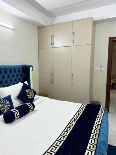 a bedroom with a bed with a blue headboard and cabinets at Penthouse in Islamabad by Bella Vista in Islamabad
