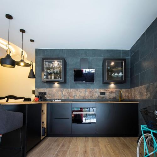 une cuisine avec des armoires noires et une cheminée dans l'établissement Love Room centre ville de Cognac, à Cognac