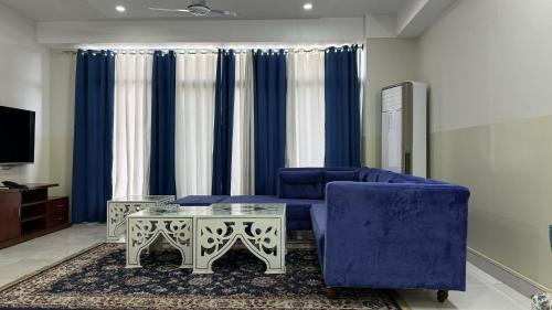 a living room with a blue couch and a table at Penthouse in Islamabad by Bella Vista in Islamabad