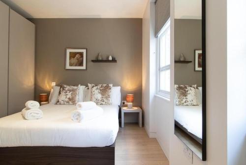 a bedroom with two beds and a window at Wells Court by Aeria Apartments in London