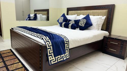 a bed with blue and white blankets and pillows at Penthouse in Islamabad by Bella Vista in Islamabad