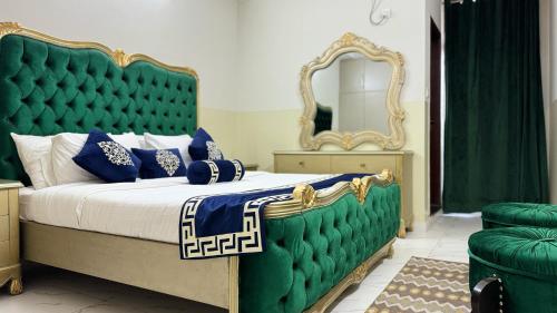 a bedroom with a large bed with a green headboard at Penthouse in Islamabad by Bella Vista in Islamabad
