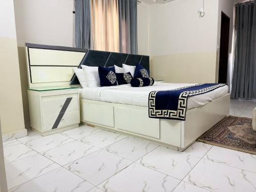 a bedroom with a bed with blue and white pillows at Penthouse in Islamabad by Bella Vista in Islamabad