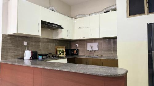a kitchen with white cabinets and a counter top at Penthouse in Islamabad by Bella Vista in Islamabad
