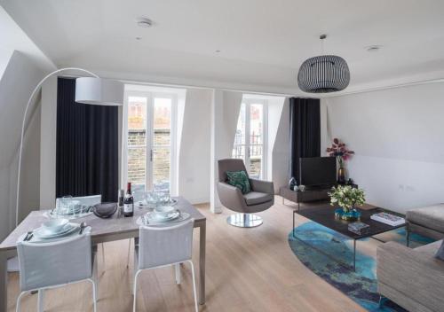a living room with a table and chairs and a couch at Wells Court by Aeria Apartments in London