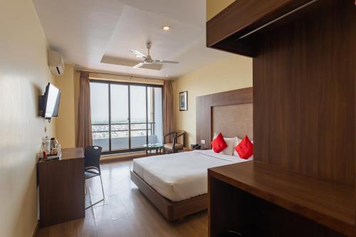 a hotel room with a bed and a desk and a window at Hotel Verandah in Itahari