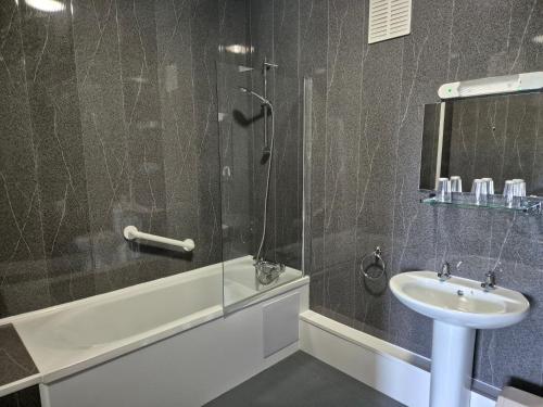 uma casa de banho com um chuveiro e um lavatório. em Trecarn Hotel em Torquay