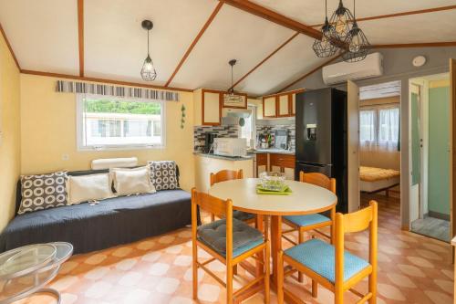 un salon avec un canapé, une table et des chaises dans l'établissement Mobilhome Mh 212, à La Tremblade