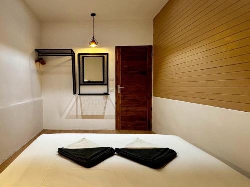 a bedroom with a bed with a bow tie on it at Minimal2 MaeHaad in Ko Tao