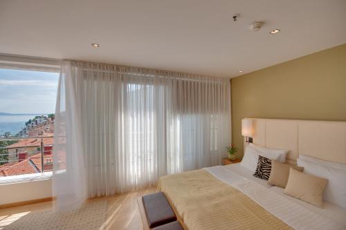 a bedroom with a large bed and a large window at ASTORIA Hotel Opatija in Opatija