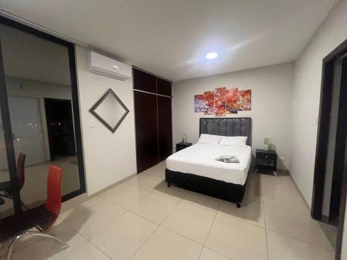 una camera da letto con un letto e una sedia di Espacio Chic a Santa Cruz de la Sierra