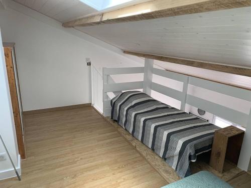 a room with a bunk bed in a attic at Natha de la Plage 2000 in Brétignolles-sur-Mer