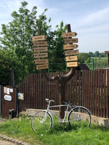a bike parked next to a tree with street signs at Domek U Labe in Stanovice