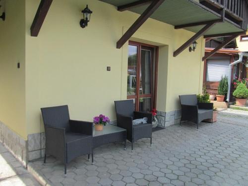 a patio with chairs and a table and a building at A+S Penzion Podzamok in Spišské Podhradie