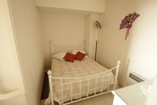 - une petite chambre avec un lit et 2 oreillers rouges dans l'établissement Le pavois de la mer, à Saint-Hilaire-de-Riez