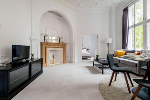 een woonkamer met een bank en een open haard bij 3 Sloane Gardens in Londen