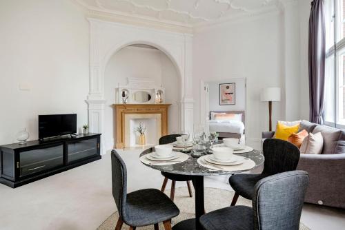 a living room with a table and chairs at 3 Sloane Gardens in London