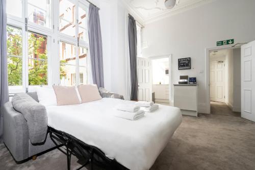 a living room with a large bed and a couch at 3 Sloane Gardens in London