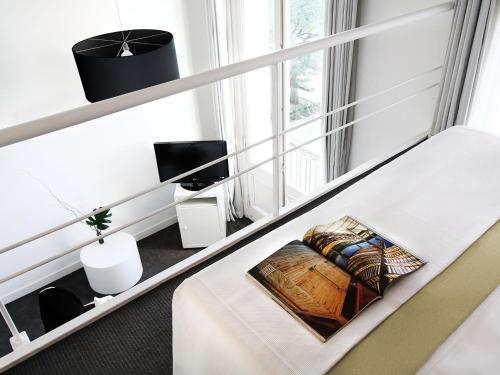 a white room with a bed and a tv at HTL 9 de Julio BsAs in Buenos Aires