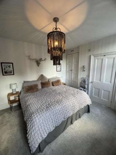 um quarto com uma cama grande e um lustre em The Bungalow em Southport
