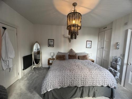 um quarto com uma cama grande e um lustre em The Bungalow em Southport
