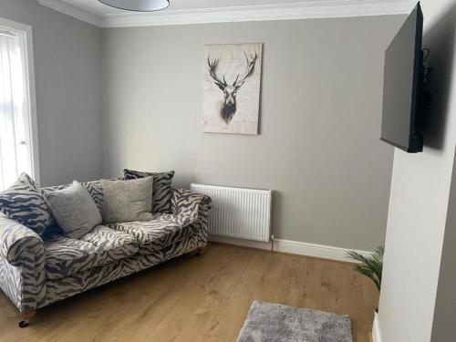 uma sala de estar com um sofá e uma pintura de veado na parede em The Bungalow em Southport