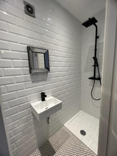 uma casa de banho branca com um lavatório e um espelho em The Bungalow em Southport