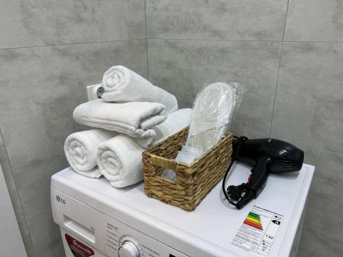 - Cesta de toallas encima de una lavadora en Красивая квартира в ЖК Sat City, en Taldykolʼ