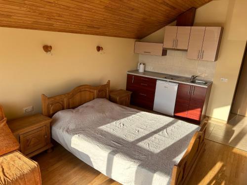 a small bedroom with a bed and a kitchen at Svečių namai Vilma in Šventoji