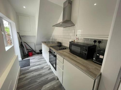 una cucina con piano di lavoro e forno a microonde di Coastal Tyneside Flat a Westoe