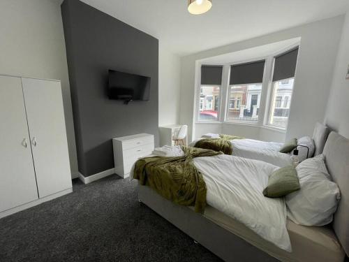 una camera con 2 letti e una TV a schermo piatto di Coastal Tyneside Flat a Westoe
