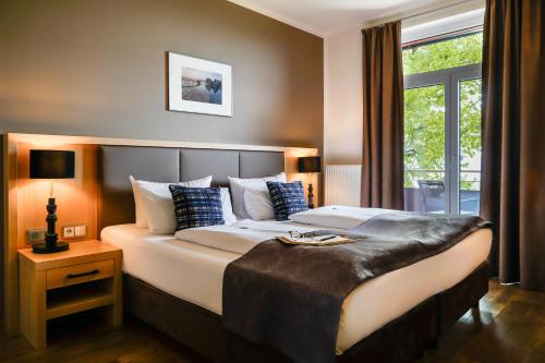 a hotel room with a large bed and a window at Bodensee-Hotel Sonnenhof in Kressbronn am Bodensee